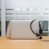 laptop with hedset on a wodden desk